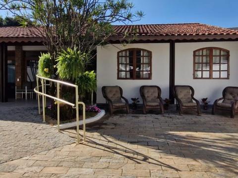 Pátio de entrada com poltronas ao lado da rampa com corrimão