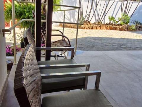 Varanda com poltronas de vime e jardim ao fundo
