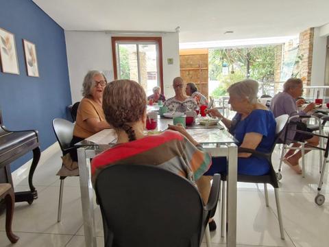 Convivência de residentes em sala com piano e parede azul