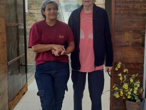 Duas pessoas lado a lado, junto a um arranjo de flores